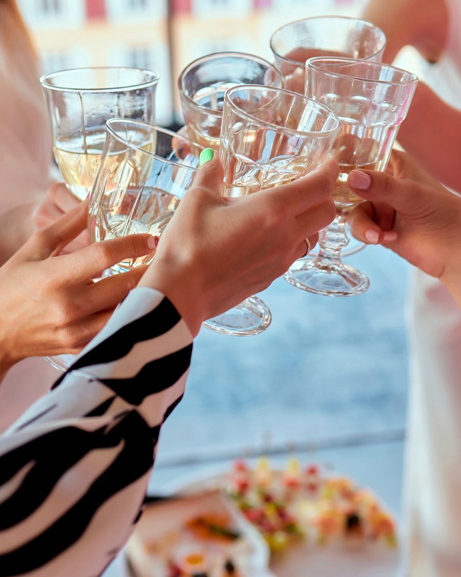 Invitati che alzano i bicchieri a tavola