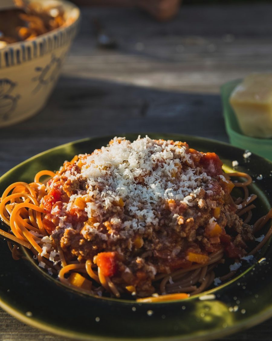 Un piatto di pasta al ragù su una tavola apparecchiata