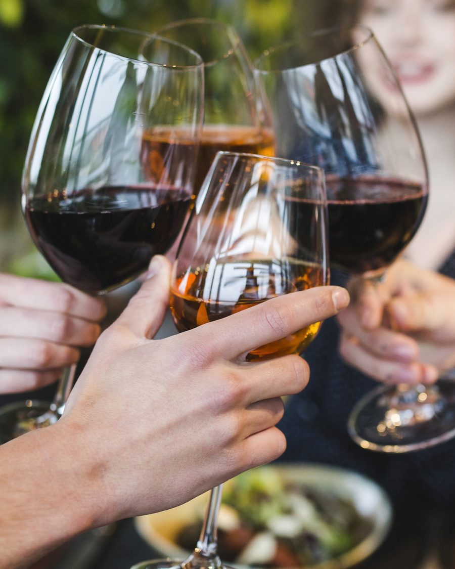 Bicchieri di vino rosso alzati sopra la tavola